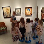 grupa dziewczynek oglądająca wystawę dzieł sztuki w galerii