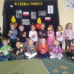grupa dzieci na tle gazetki z napisem: 
