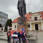 grupa sześciu dziewczynek stojąca przed pominiek Piłsudskiego z napisem: 