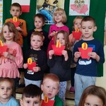 grupa dzieci trzymająca w rękach znicze z papieru 