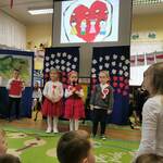 Troje dzieci mówiących wierszyk przez mikrofon 