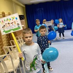 Dzieci maszerujące po sali z transparentami i balonami