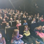 Grupa dzieci siedząca na widowni teatru 