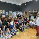 Grupa ludzi siedzących w Muzeum Historycznym, Pani Dyrektor wręczającą nagrody