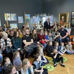 Grupa ludzi siedzących w Muzeum Historycznym