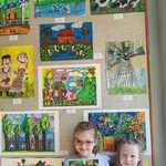 Dziewczynki stojące na tle wykonanych prac plastycznych 