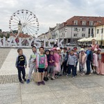 Grupa dzieci stojąca na Rynku Kościuszki w Białymstoku 