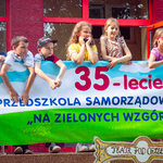 Dzieci nad banerem z napisaem 35-lecie przedszkola .jpg