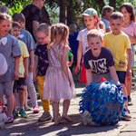 Chłopiec toczacy kulę i dzieci stojace w rzędzie.jpg