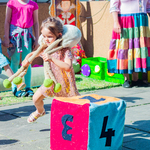 Dziewczynka z owcą na plecach biegnaca na około kostki.jpg