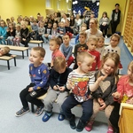 Dzieci z grupy Pszczółki siedzą na ławkach i śpiewają kolędy