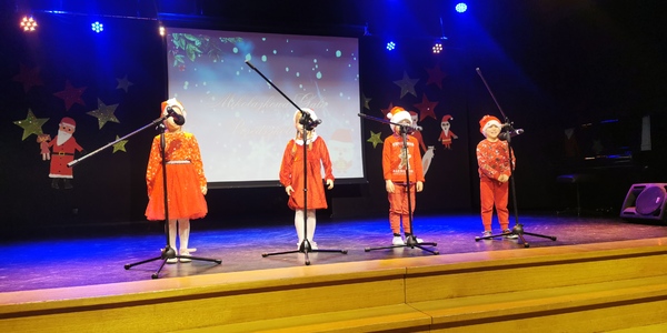 Dzieci na scenie śpiewające do mikrofonów