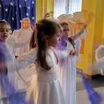 Dziewczynki przebrane za anioły wykonując taniec z chustami 