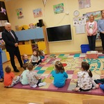 Muchomorki siedzą na dywanie, rozmawiają z Panią Dyrektor i Panem Prezydentem Miasta Białegostoku