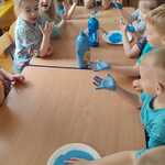 Dzieci odbijają dłonie w niebieskiej farbie 
