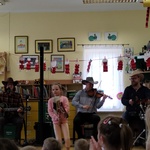Dziewczynka tańczy na drewnianym koniu do muzyki country 
