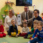 Dorośli i dzieci siedzą na dywanie