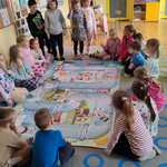 Dzieci grają w grę planszową na dywanie