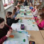 Grupa dzieci wykonuje pracę plastyczną
