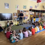 Grupa dzieci słucha pani policjantki.JPG