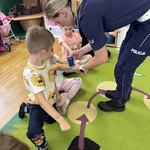 Pani policjantka stawia chłopcu pieczątkę na ręce 