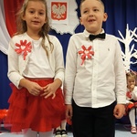 Dziewczynka i chłopiec w strojach galowych na scenie