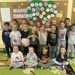 Grupa uśmiechniętych dzieci w sali przedszkolnej