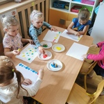 Dziewczynki przy stoliku stawiają kolorowe kropki na kartach